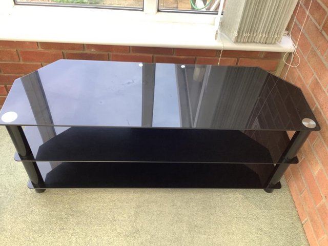 Preview of the first image of Large black glass television stand.
