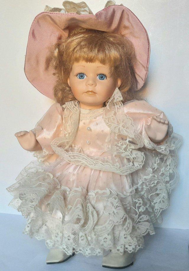 Preview of the first image of LEONARDO PORCELAIN DOLL - PINK SATIN - 32 cm.