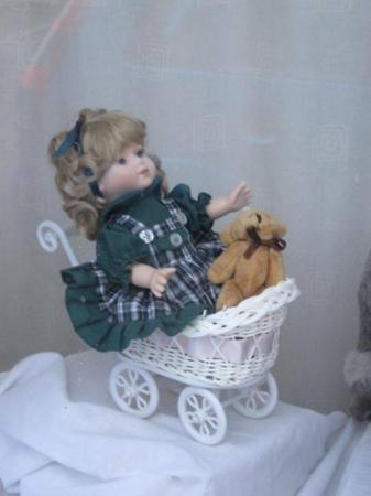 Image 1 of small baby doll with teddy bear sitting in a pram brand new