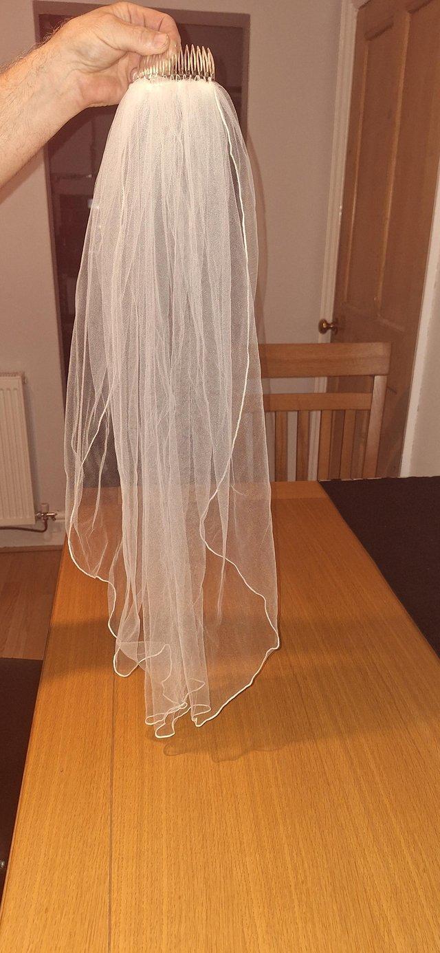 Preview of the first image of Size 16 ivory wedding dress/short ivory veil.