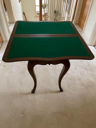 Image 1 of Dark wood folding card table . Solid construction .