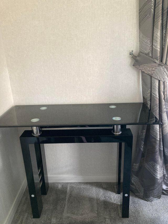 Preview of the first image of Stylish Glass & Black Console Table.