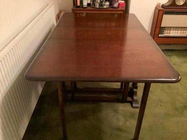 Image 2 of Solid and Heavy Dark Stained Drop-Leaf Table.