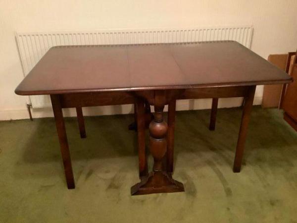 Image 1 of Solid and Heavy Dark Stained Drop-Leaf Table.