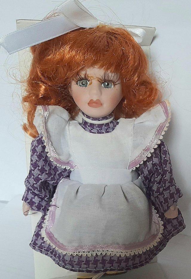 Preview of the first image of BOXED PORCELAIN DOLL - MILLIE - MAUVE DRESS 16 cm.