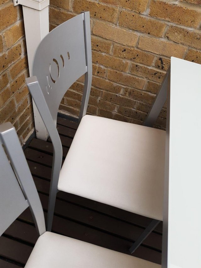 Preview of the first image of White glass top dining table and four chairs.