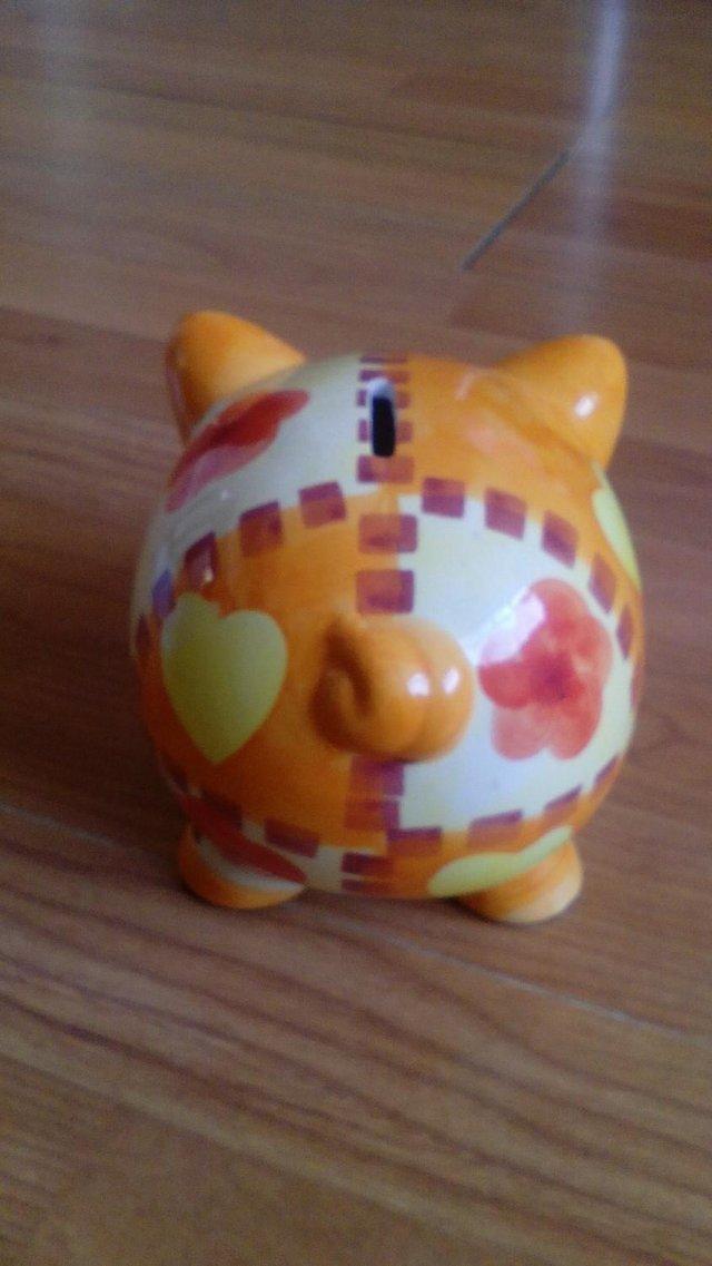 Preview of the first image of PERCY PIG ORANGE CERAMIC MONEY BOX.