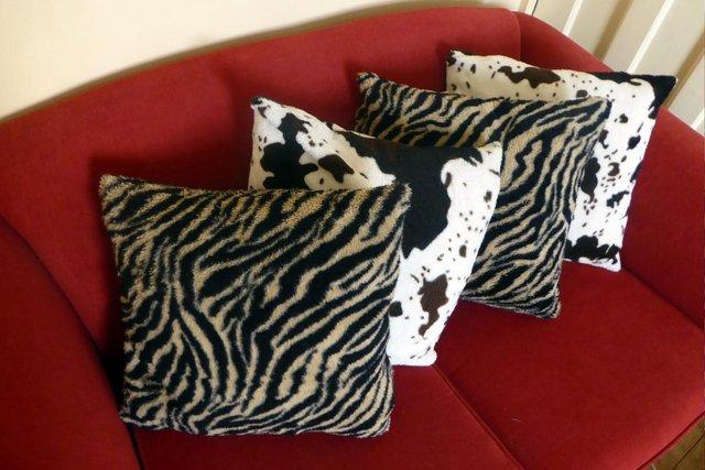 Preview of the first image of Four animal print cushions, tiger and cow.