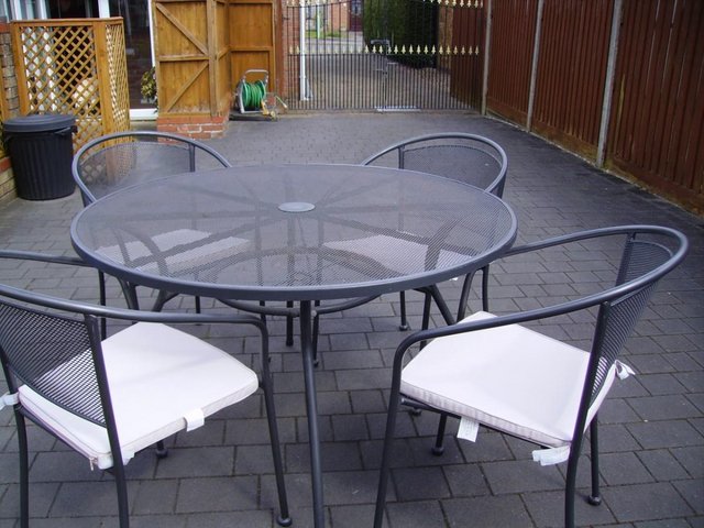 Preview of the first image of Grey metal garden table & 4 chairs with pads.
