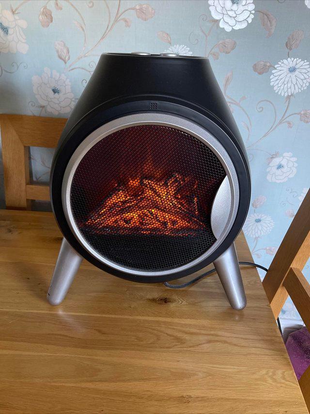 Preview of the first image of Round black Electric fan heater With log effect.