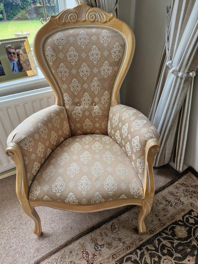 Preview of the first image of French style arm chair upholstered in gold patterned fabric.