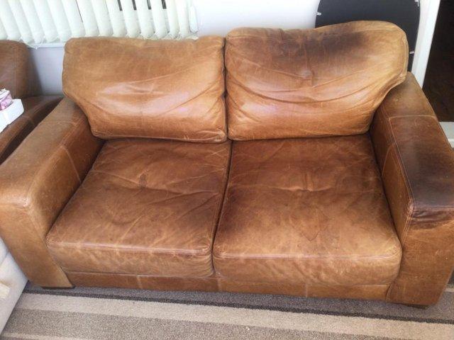 Preview of the first image of Distressed tan leather 2 seater sofa.