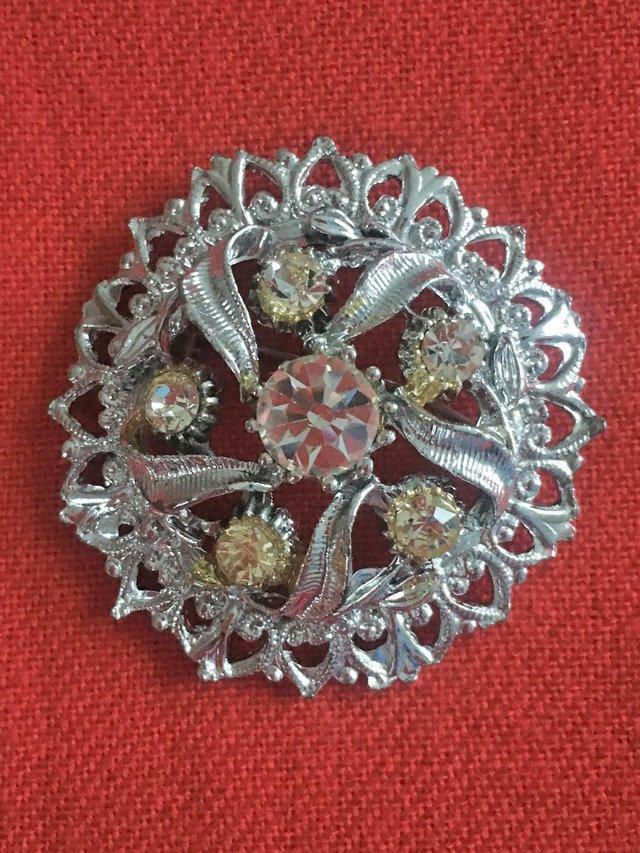 Preview of the first image of Pretty vintage silvertone and clear stones circular brooch..