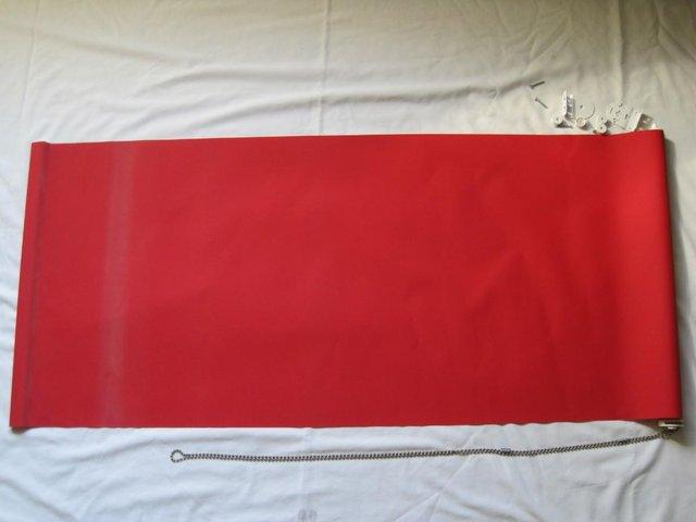 Preview of the first image of Red roller blind with fixing brackets.