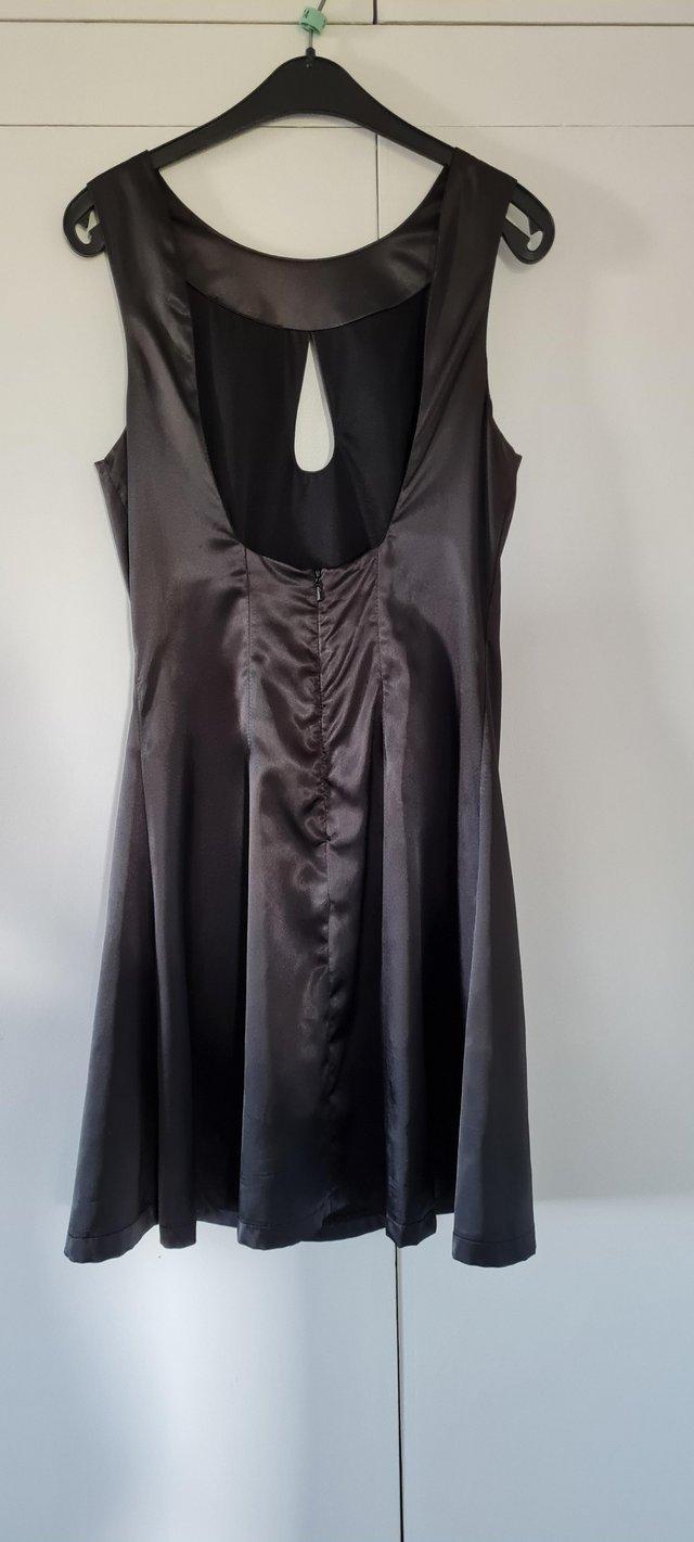 Preview of the first image of Size UK 8 Black satin dress with gem neck detailing.