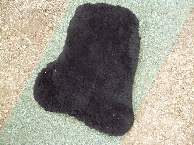 Preview of the first image of Black KM real Sheepskin Seat Saver  fits 17" saddle.