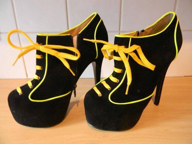 Preview of the first image of Girls black yellow high heal party shoes Condition good.
