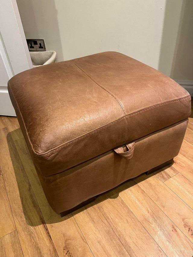 Preview of the first image of Brown leather footstool. Hinged with storage inside..