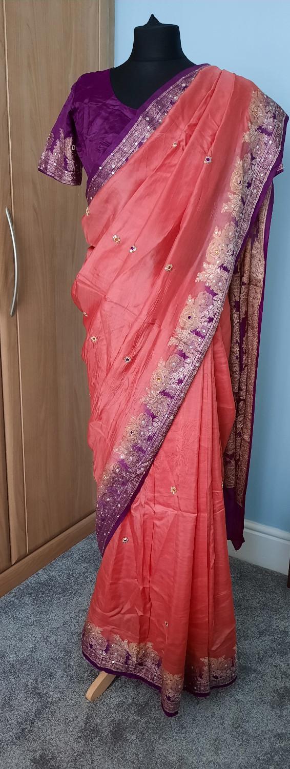 Preview of the first image of Coral pink and purple with gold embroidery design saree.