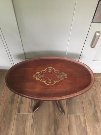Image 2 of A mahogany oval pedestal table with brass inlay at centre.