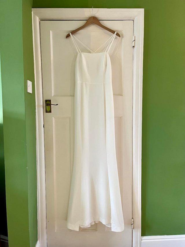 Preview of the first image of WHISTLES IVORY WHITE STRAPPY MINIMAL MAXI WEDDING DRESS.