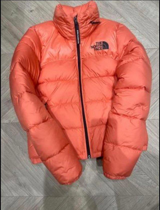 Preview of the first image of The northface orange /coral xs puffa coat.