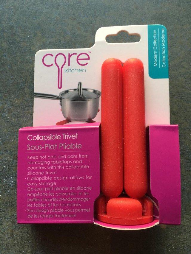 Preview of the first image of NEW red Core silicone collapsible trivet, original packaging.