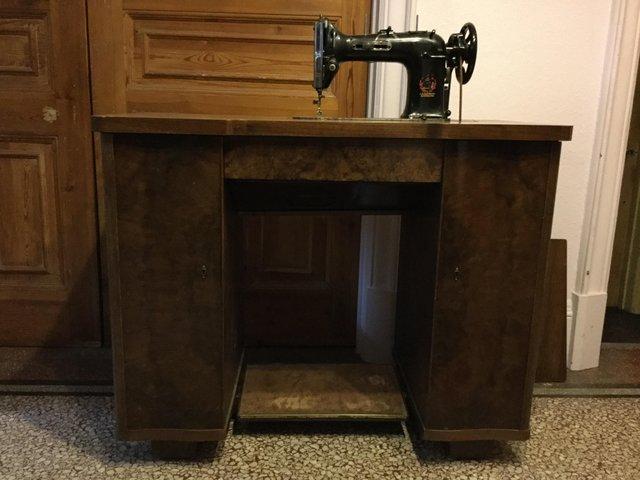 Preview of the first image of Antique sewing machine in custom-made table.