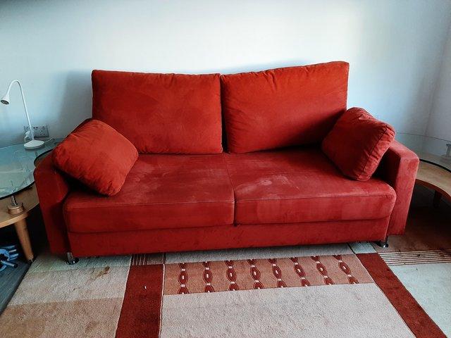 Preview of the first image of Red sofa with metal feet and pullout bed with storage.