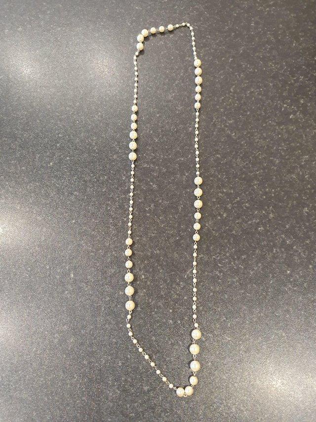 Preview of the first image of Long pearl effect & silver colour bead necklace.