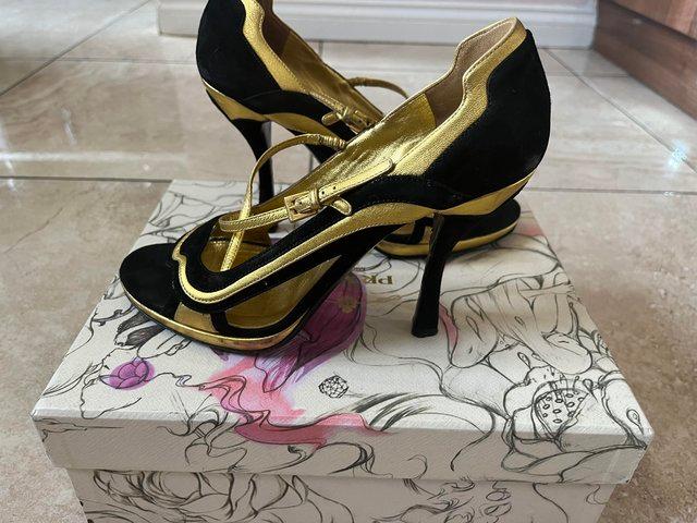 Preview of the first image of Black and gold Prada high heels.